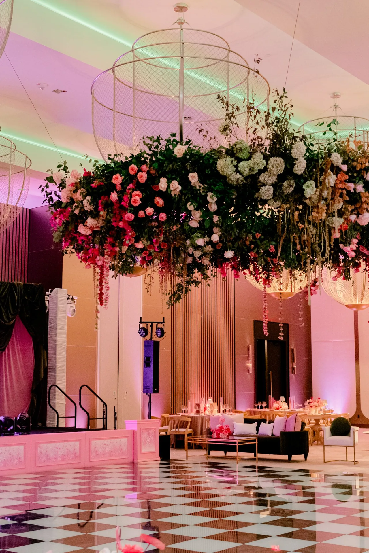 Suspended floral installation above a checkered dance floor